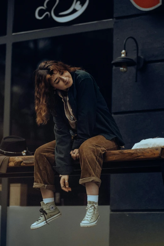 a man with long hair is sitting on a bench and smiling