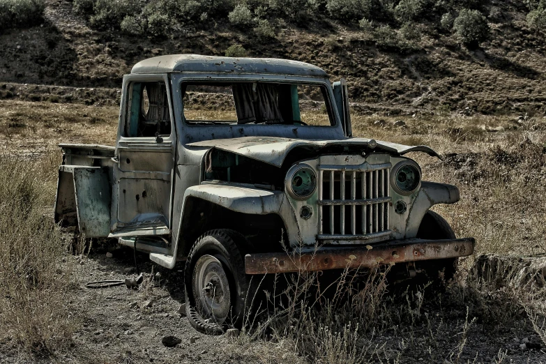 a very old truck parked in some weeds