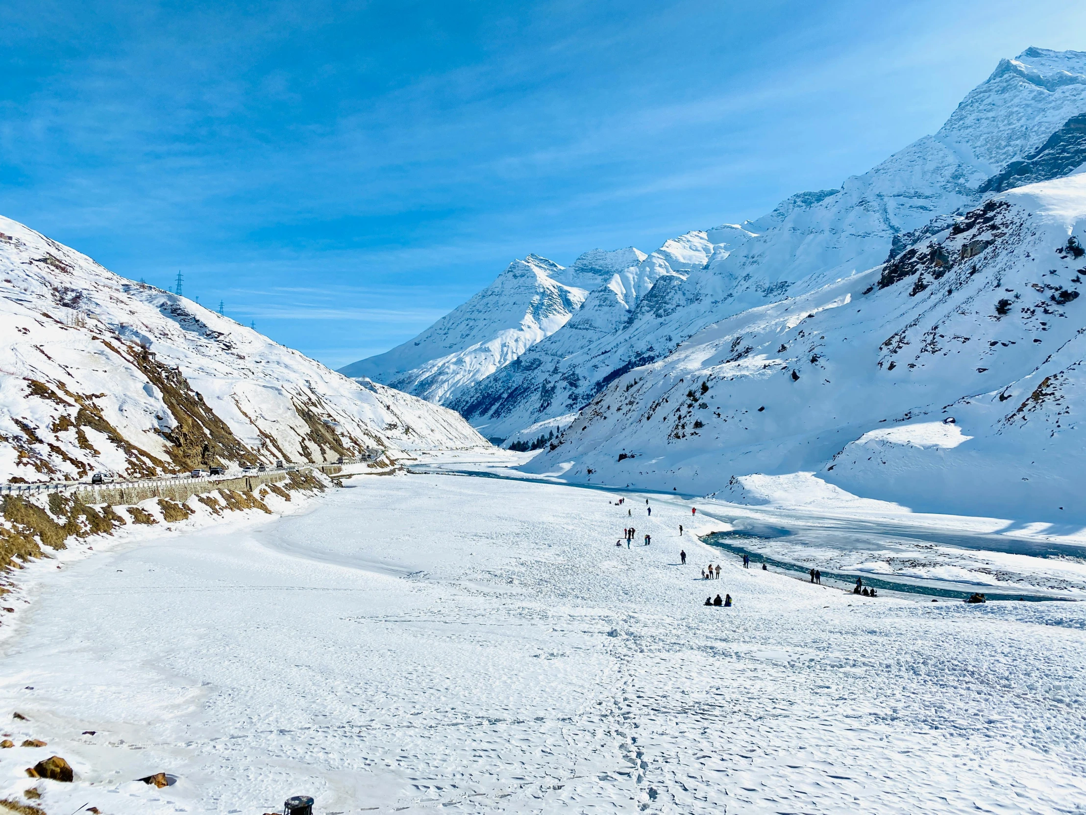 a large snow filled mountain with a river flowing down the side