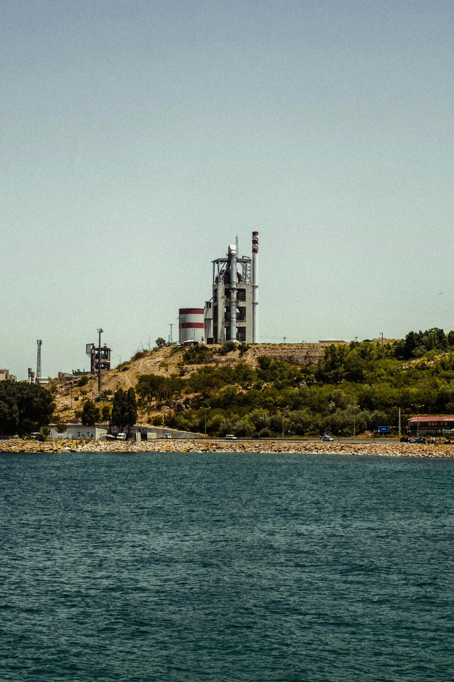 an industrial power plant at the shore of a bay