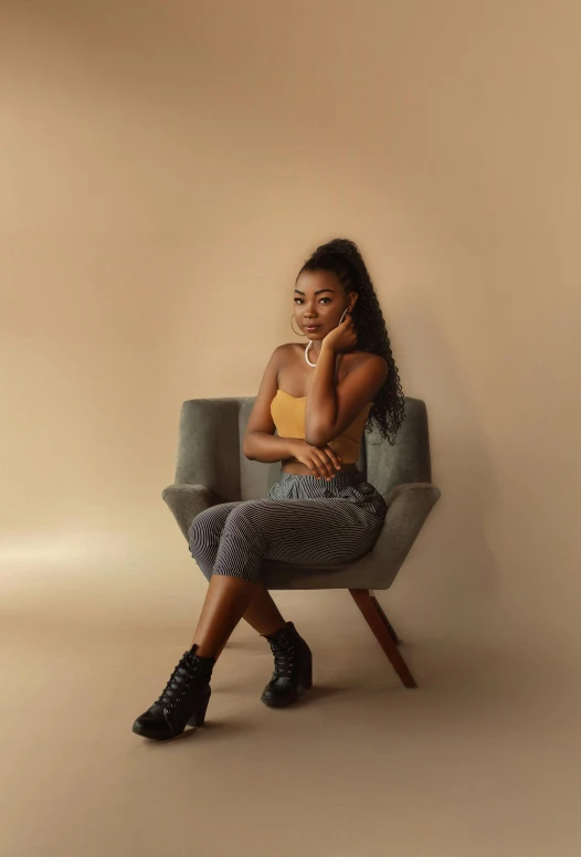 a girl is sitting on a chair with her hands crossed
