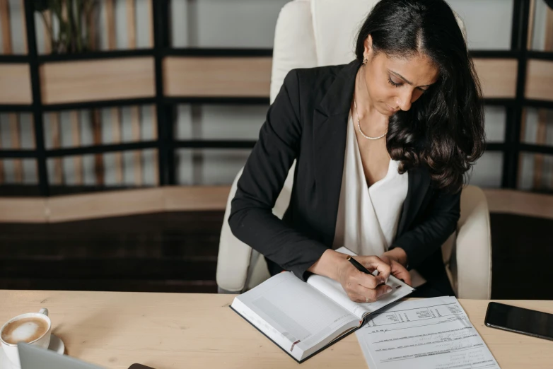 woman sitting at a table with papers and pen