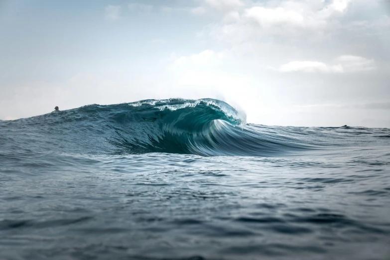 surfer in the middle of the ocean on a very big wave