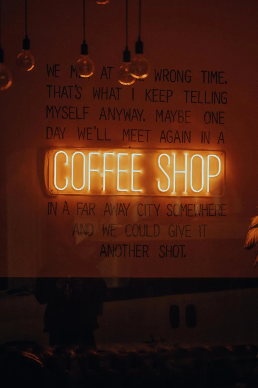 a coffee shop sign lit up in the dark