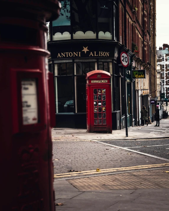 a red telephone booth on a corner next to a building