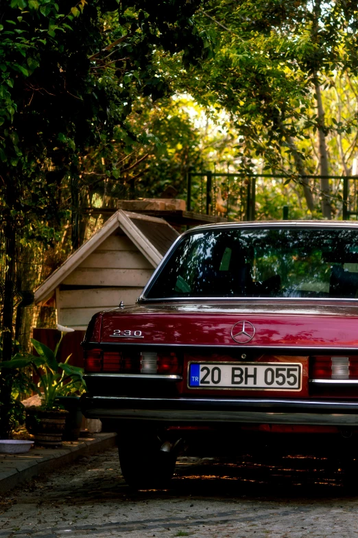 a red car parked next to a wooden building