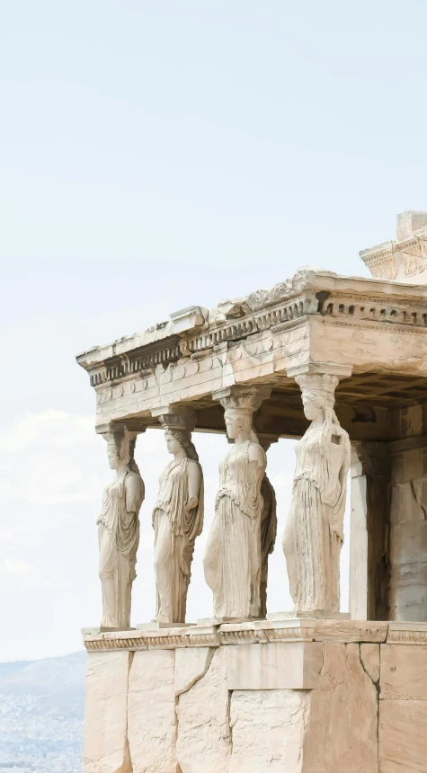 some white statues and a building on a hill