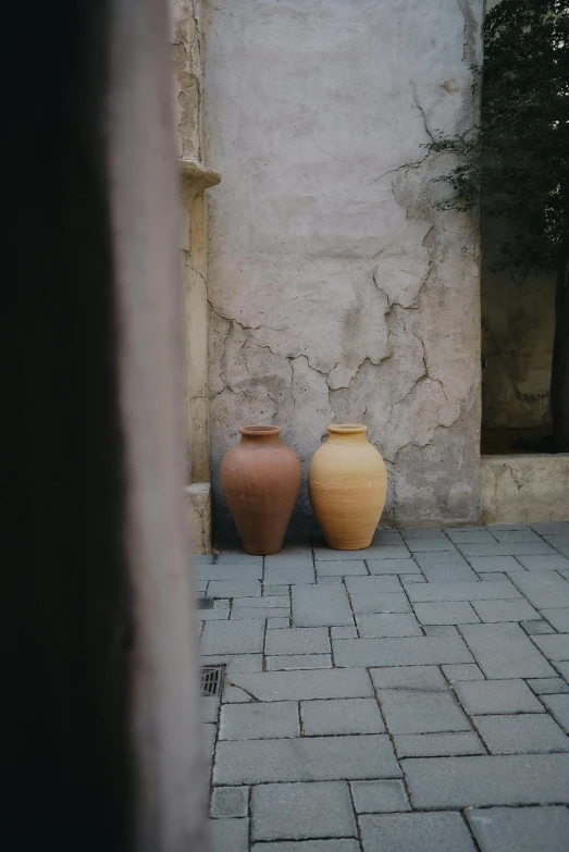 two large vases are sitting outside beside each other