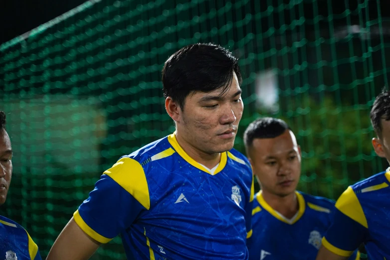 a group of asian men standing on a soccer field