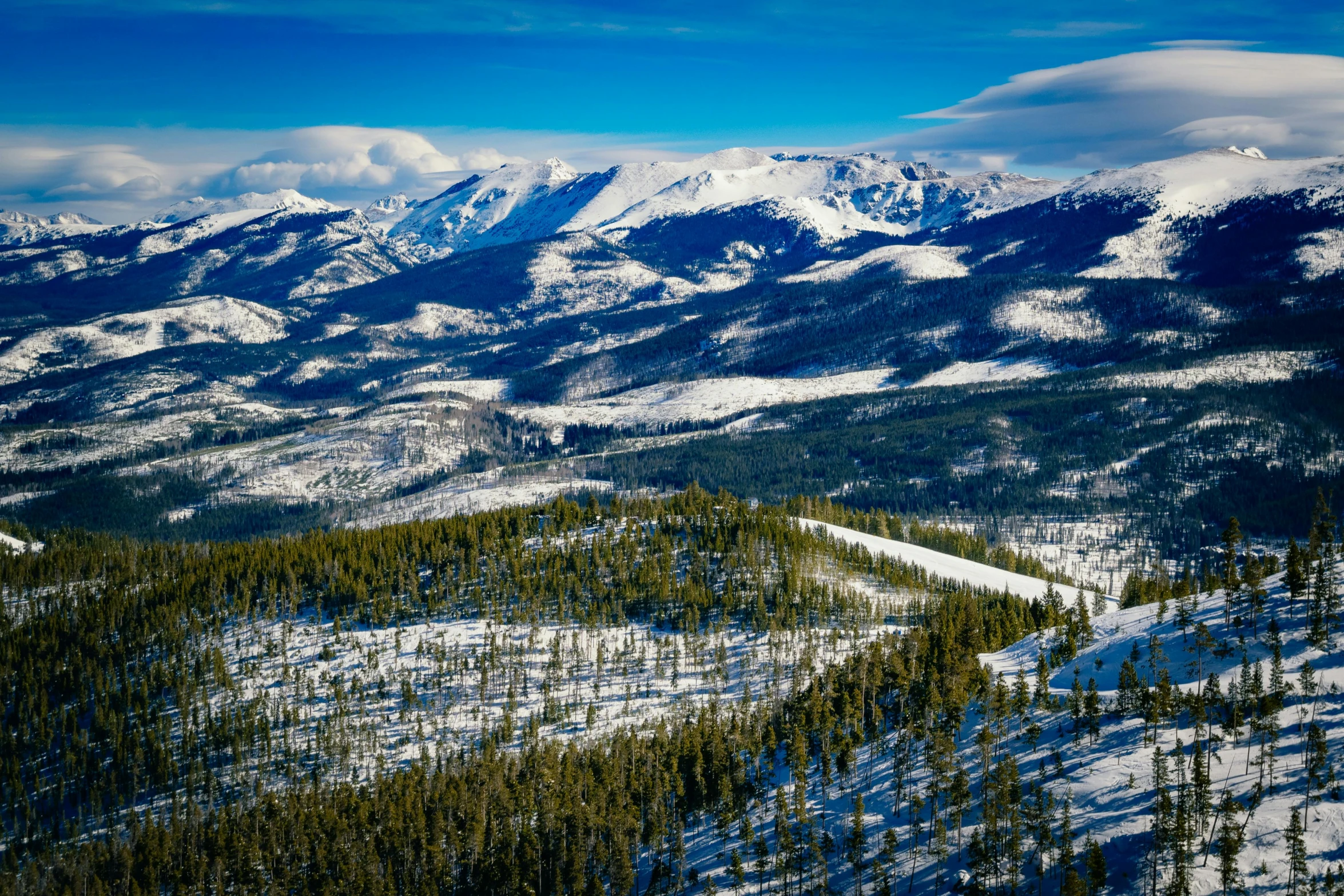 a wide mountain range with snow covered mountains