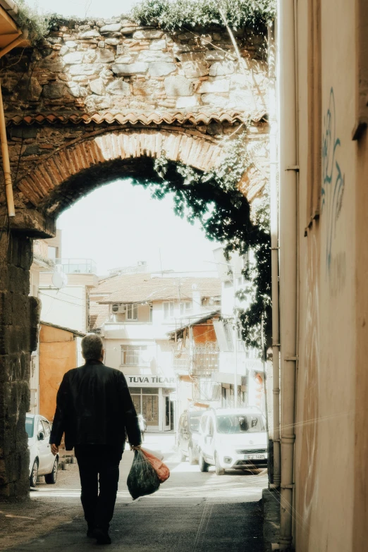 the man carries bags in a tight alleyway