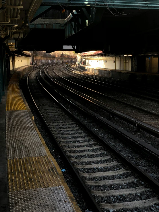 looking down the tracks in a train station at night