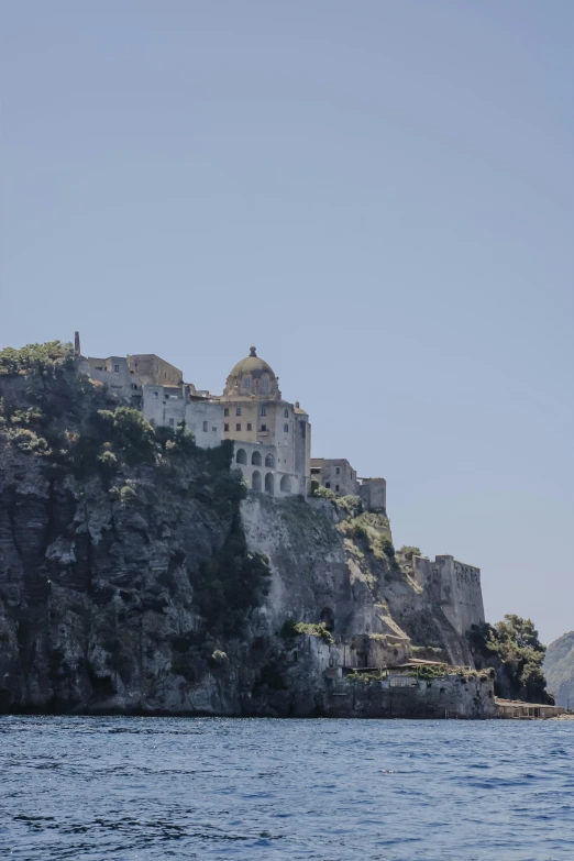 there is a castle on top of a mountain near the ocean