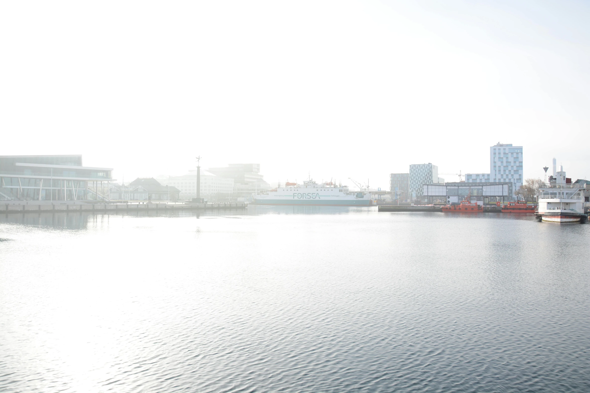 a row of boats sitting in a harbor next to a city