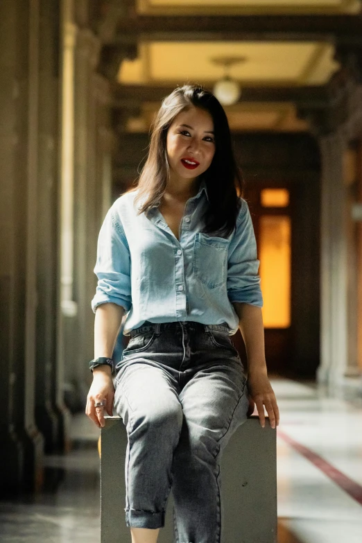 a woman in jean shorts sits on a suitcase