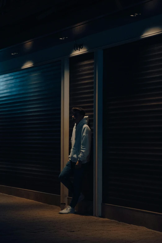 a man standing in front of the closed garage doors of a building