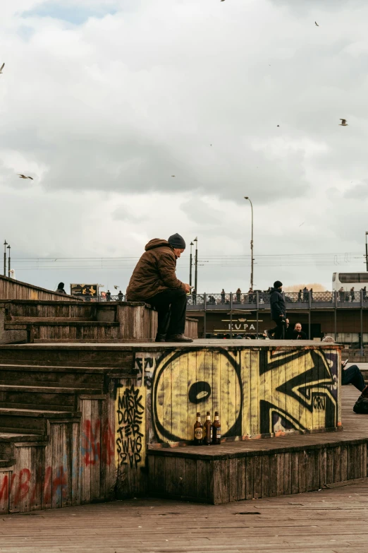 a man with a hat sitting on top of an artistic wooden structure