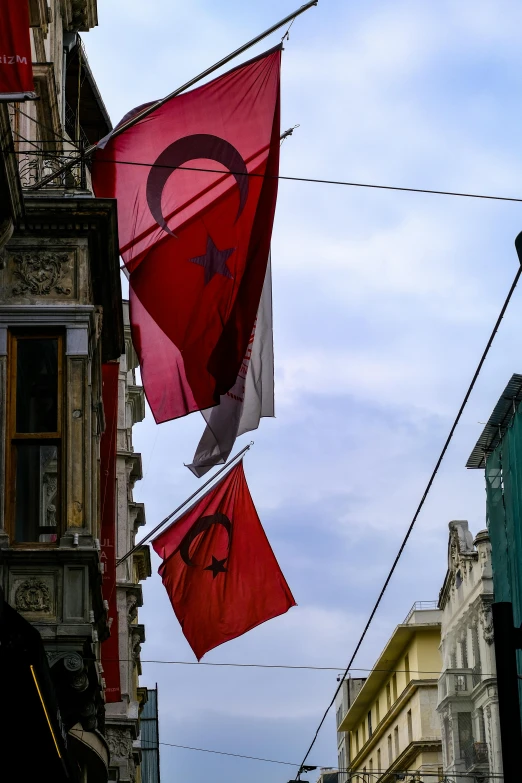 a group of flags flying in the air near a street light