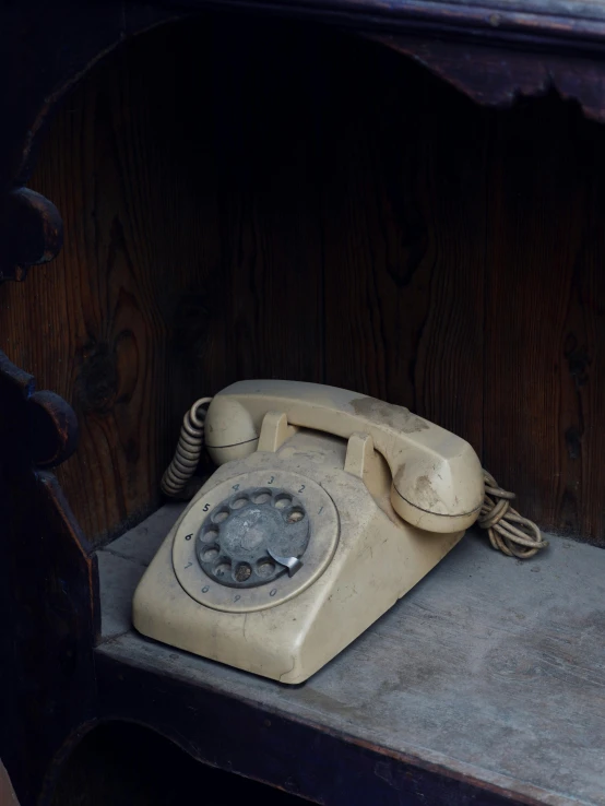 an old telephone sits atop a shelf
