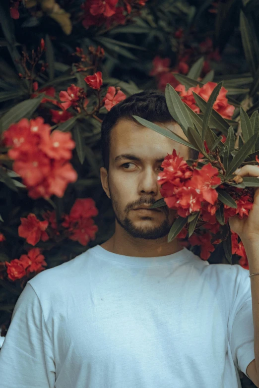 man standing by flowers with beard and eye open