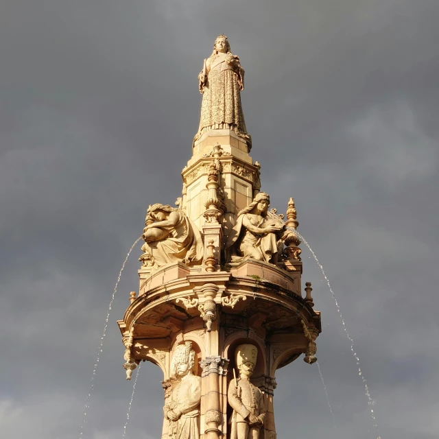 an ornate fountain with statues on the sides of it