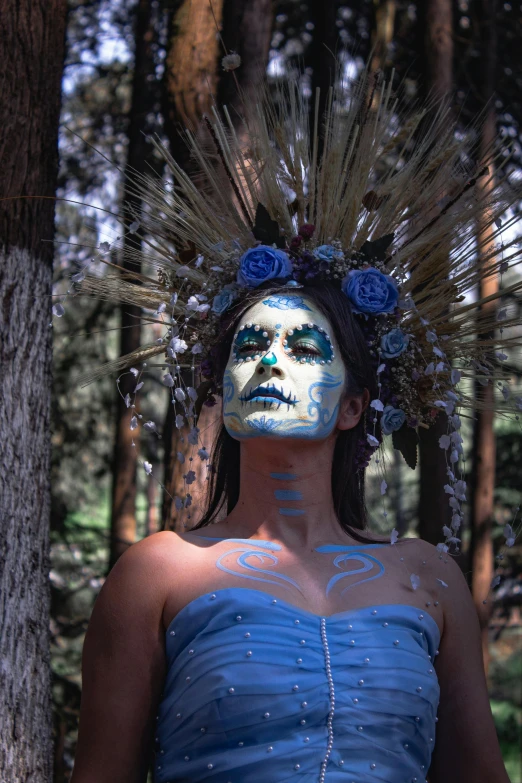 a girl with makeup and feathers and hair in the forest