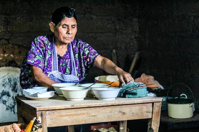 a woman sits at a table with several bowls of food