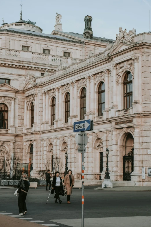 two women walking across a cross walk next to a building