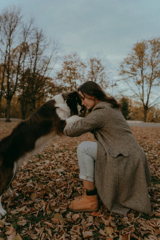 a woman is petting a dog in a field