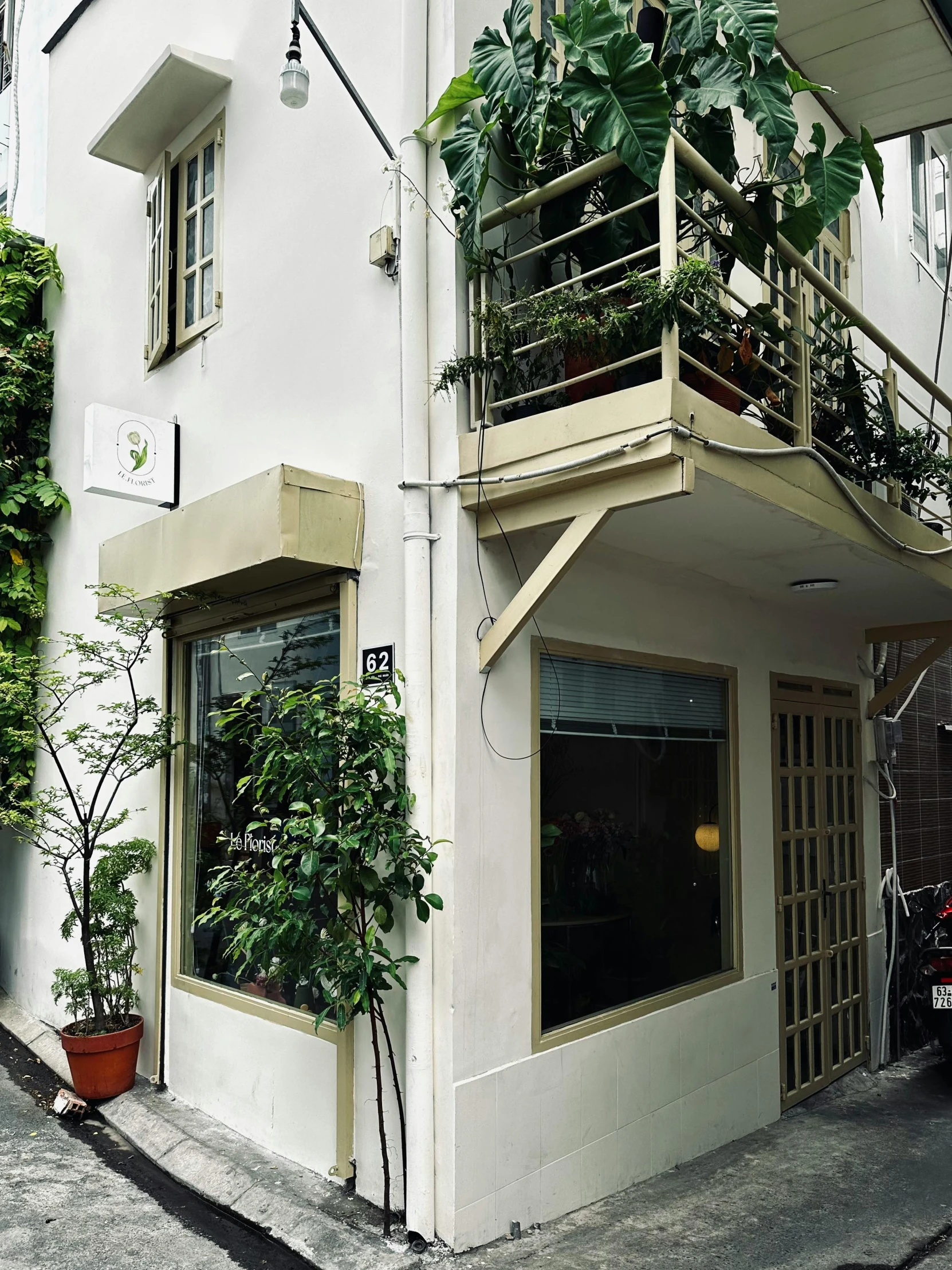 the back of a white house with plants on the outside