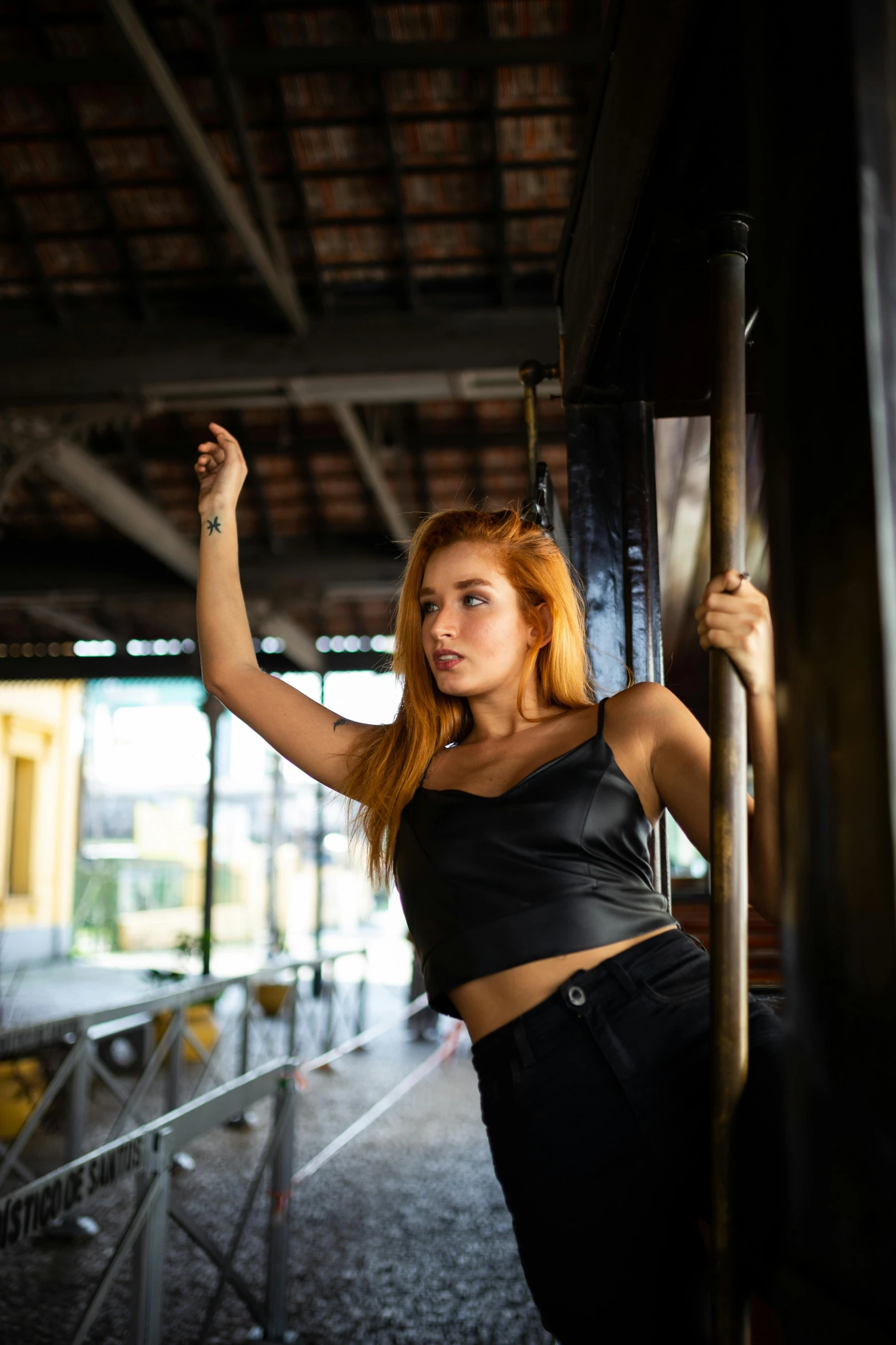 a woman posing with a pole in the background