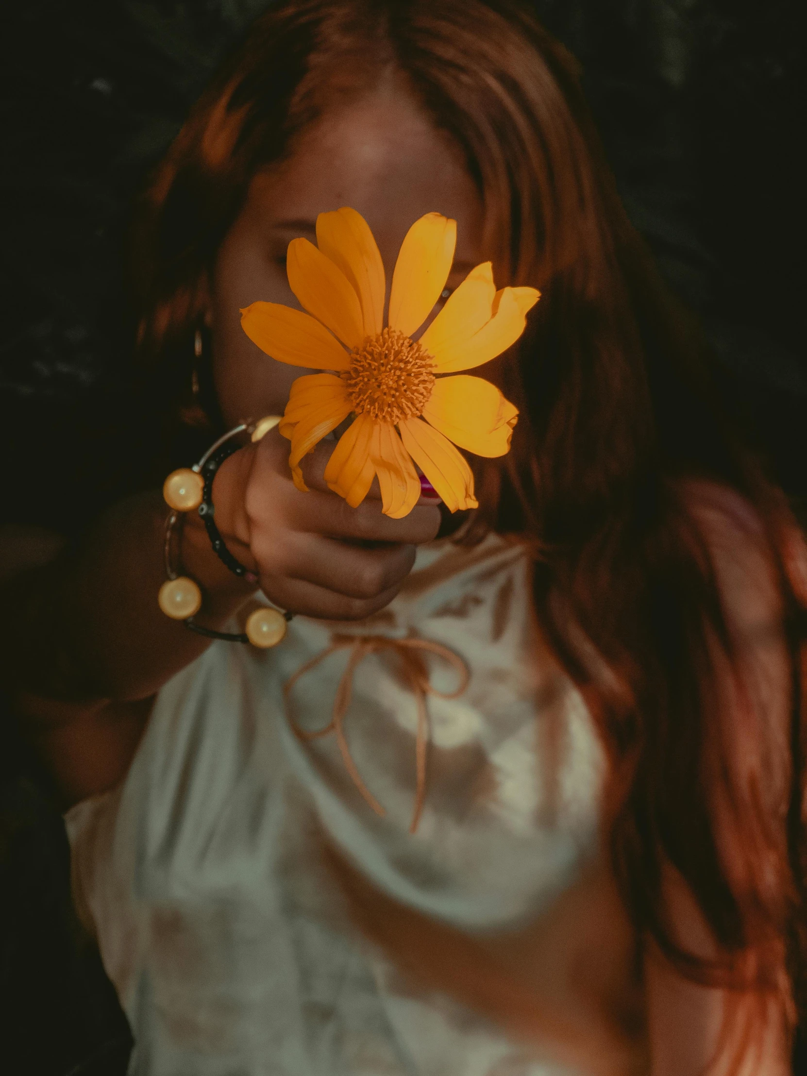 a woman holding a flower up to her face