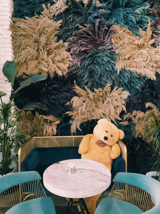 a stuffed bear on a chair at a table