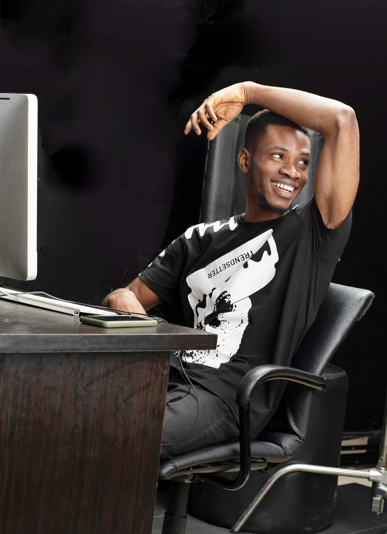 an african american man smiles as he rests his arms in his office chair