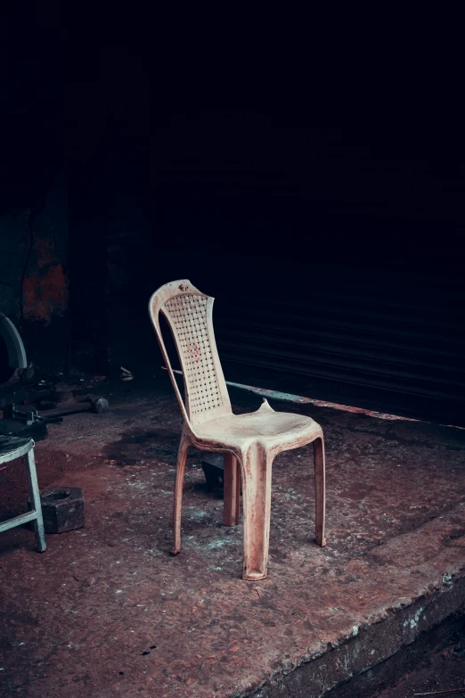 a white chair sitting in the dirt outside