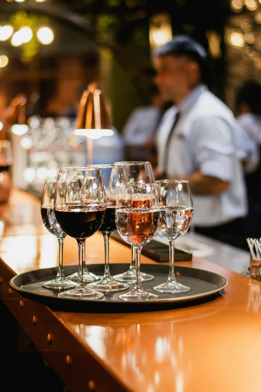 a bar with glasses of wine and two men