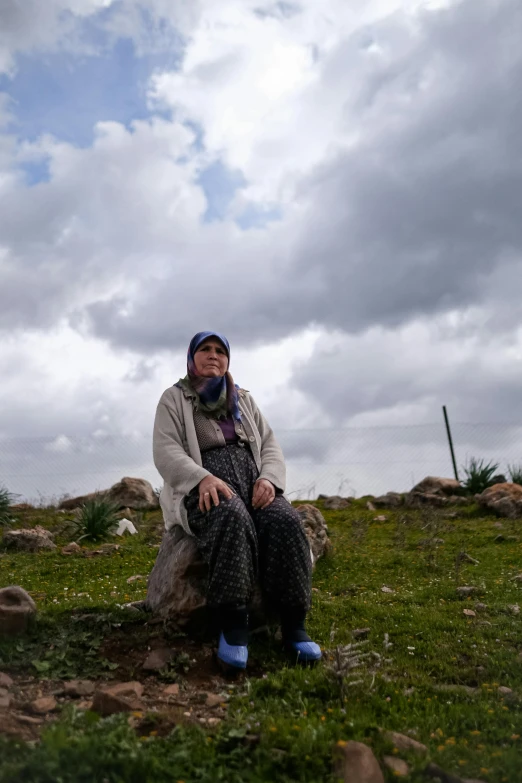 a woman in the background sitting on a rock