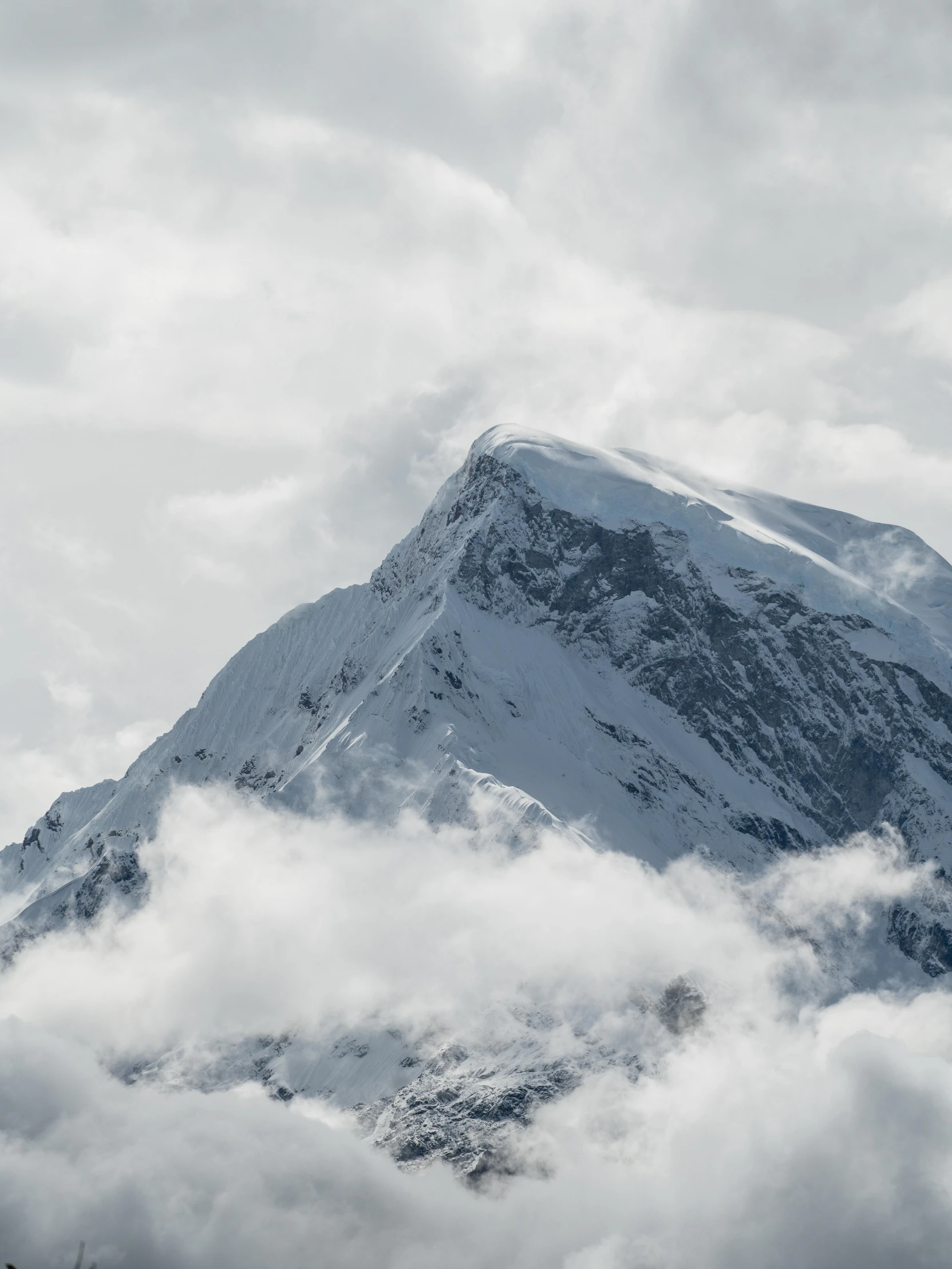 mountain surrounded by white clouds under a cloudy sky