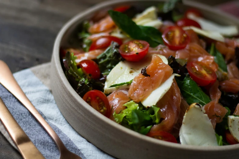 a bowl filled with meat, cheese, and vegetables