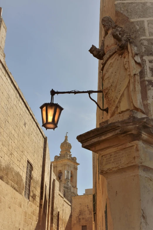 a lamp on a pole near some stone buildings