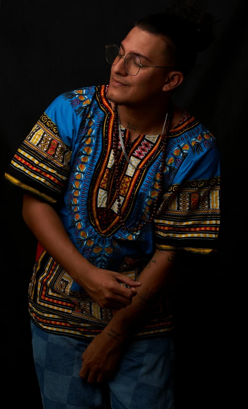 a woman in an african - styled colorful shirt poses for the camera