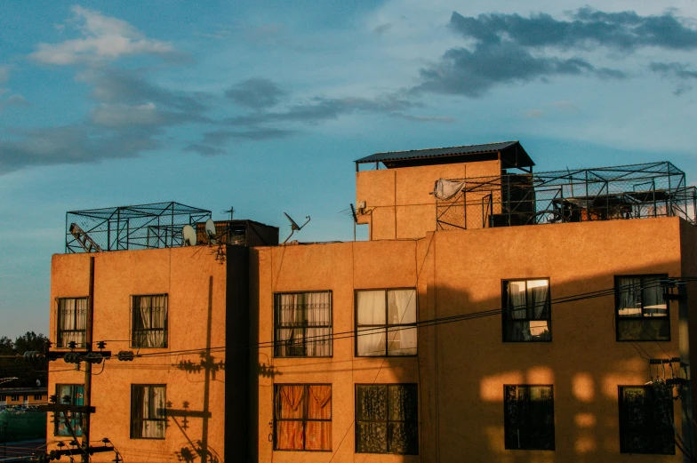 a tan apartment building with two stories on a cloudy day