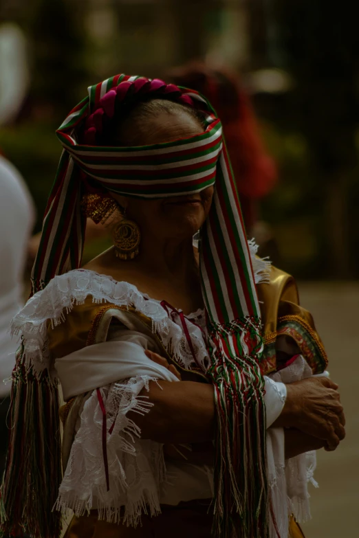 a woman in the traditional mexican costume looking at soing