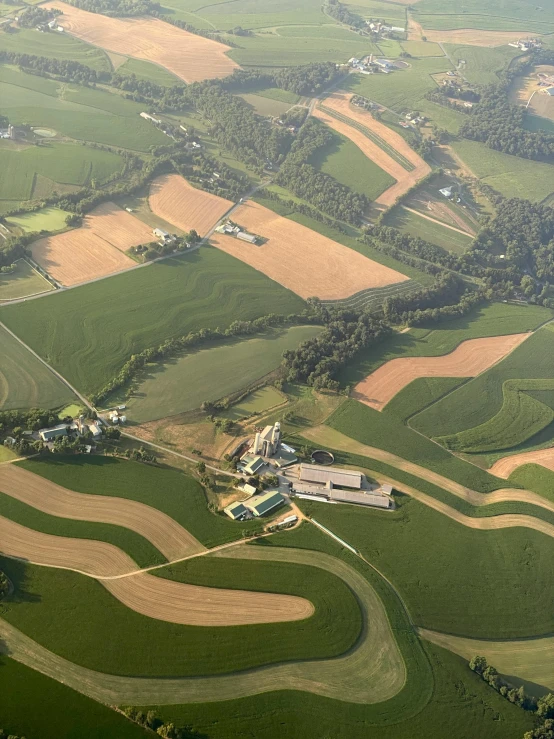 an aerial po of green farm land with some hills