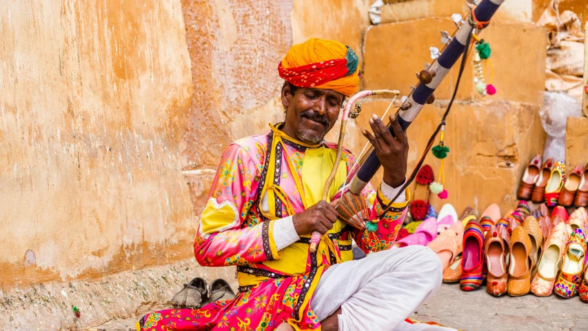 a man in traditional garb plays a musical instrument