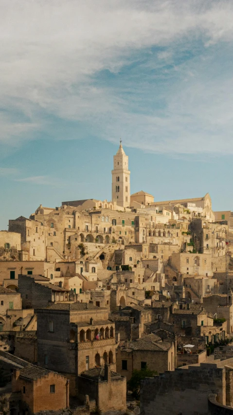 view over rooftops of a city under a blue cloudy sky