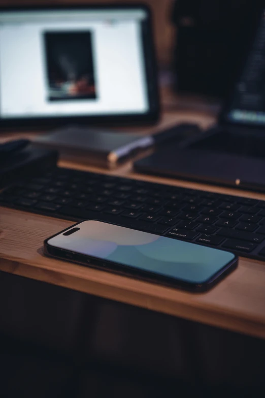 a phone is sitting on a desk next to a laptop