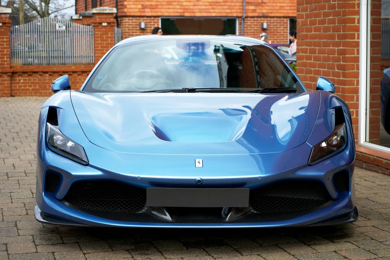 a blue sports car parked next to a brick building