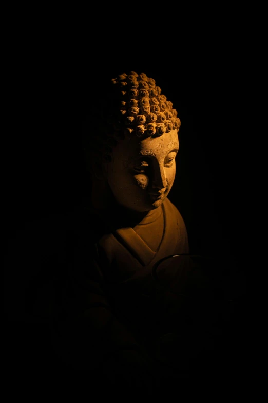 a lit buddha statue in a dark room