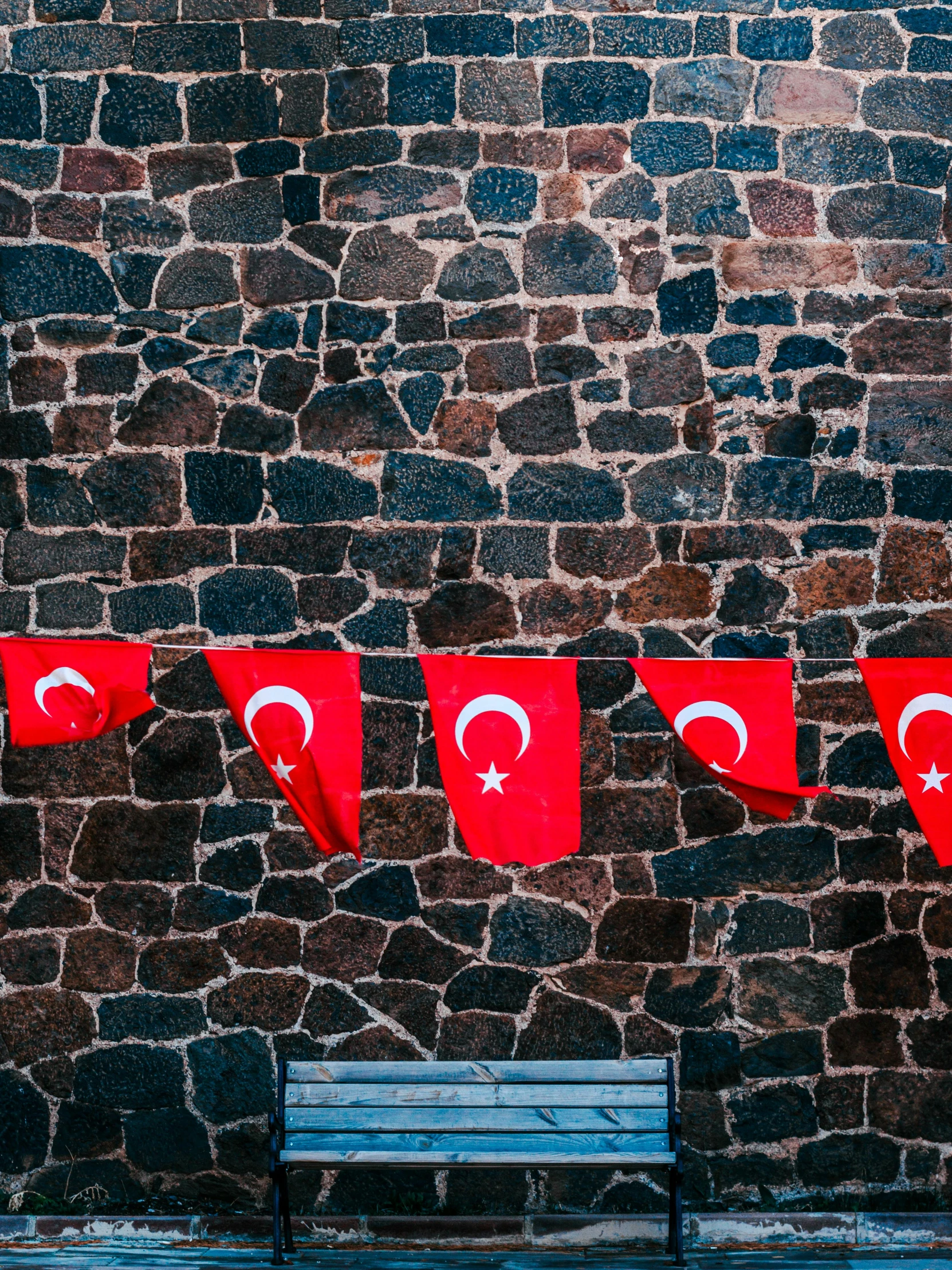 a stone wall with flags hanging on the side